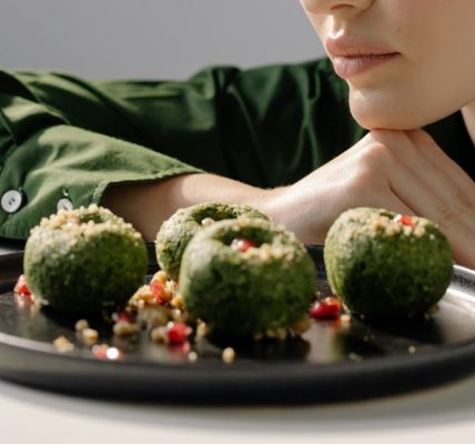 Close-up of spinach pkhali, a Georgian vegan dish, with a woman in green observing.